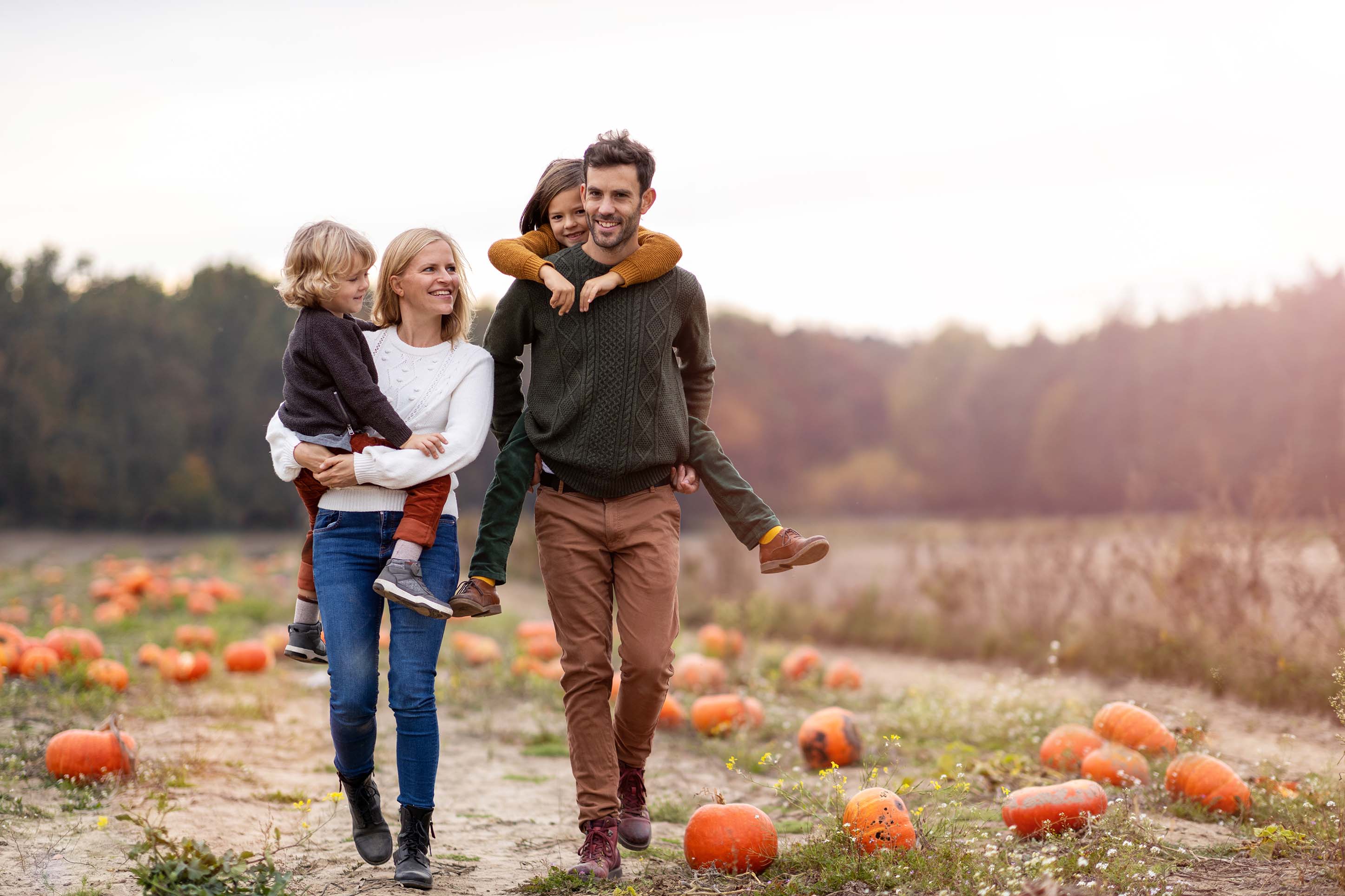 family walking through a pumpkin patch together