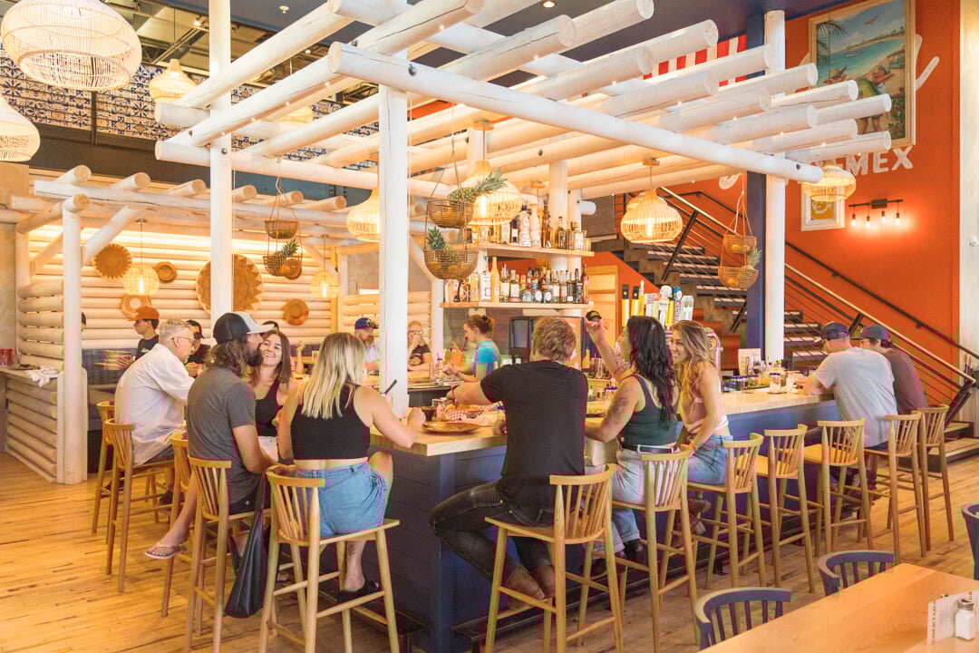 People eating and drinking at the bar area inside the Merry Piglets restaurant