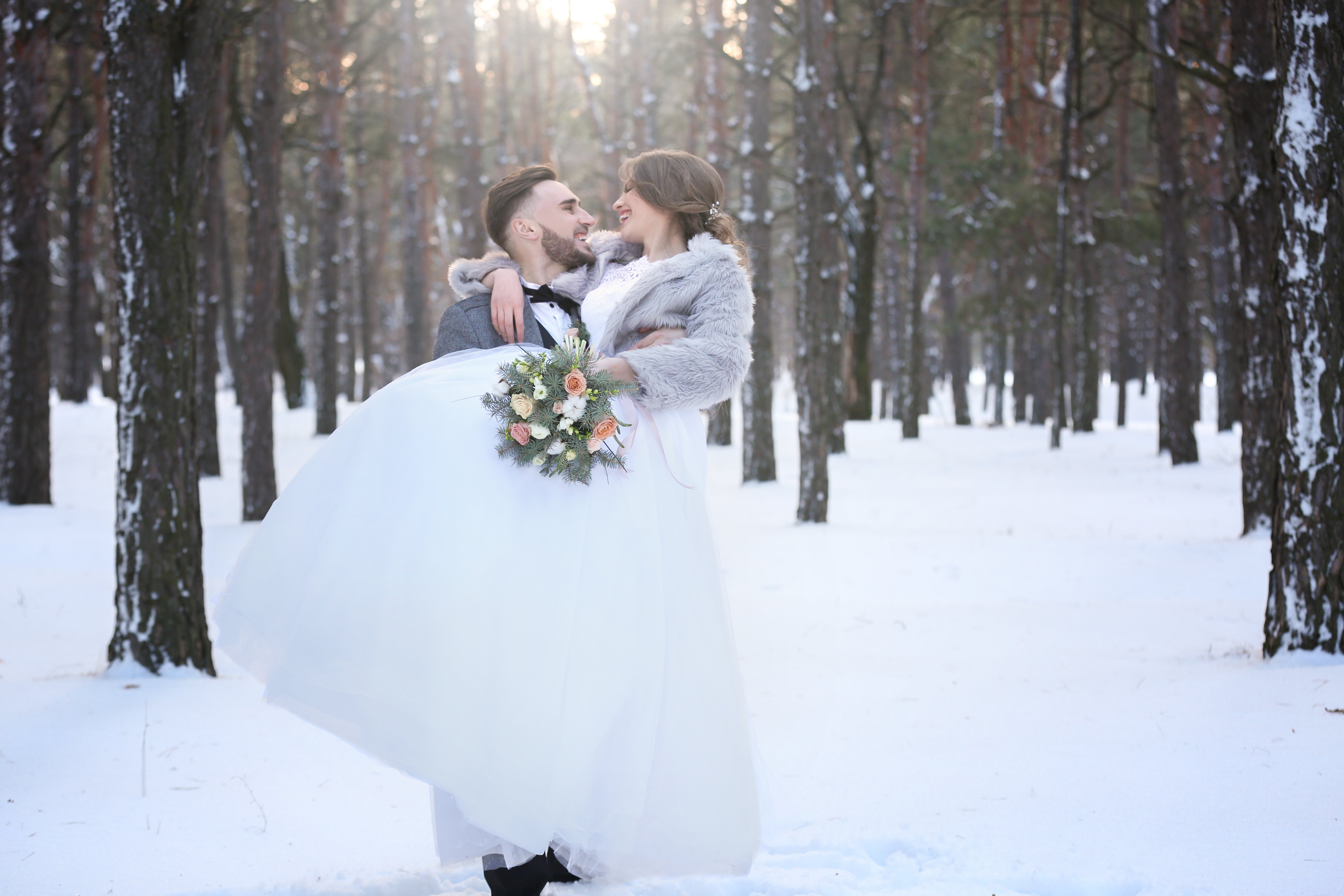 couple embracing in the snow at their winter wedding