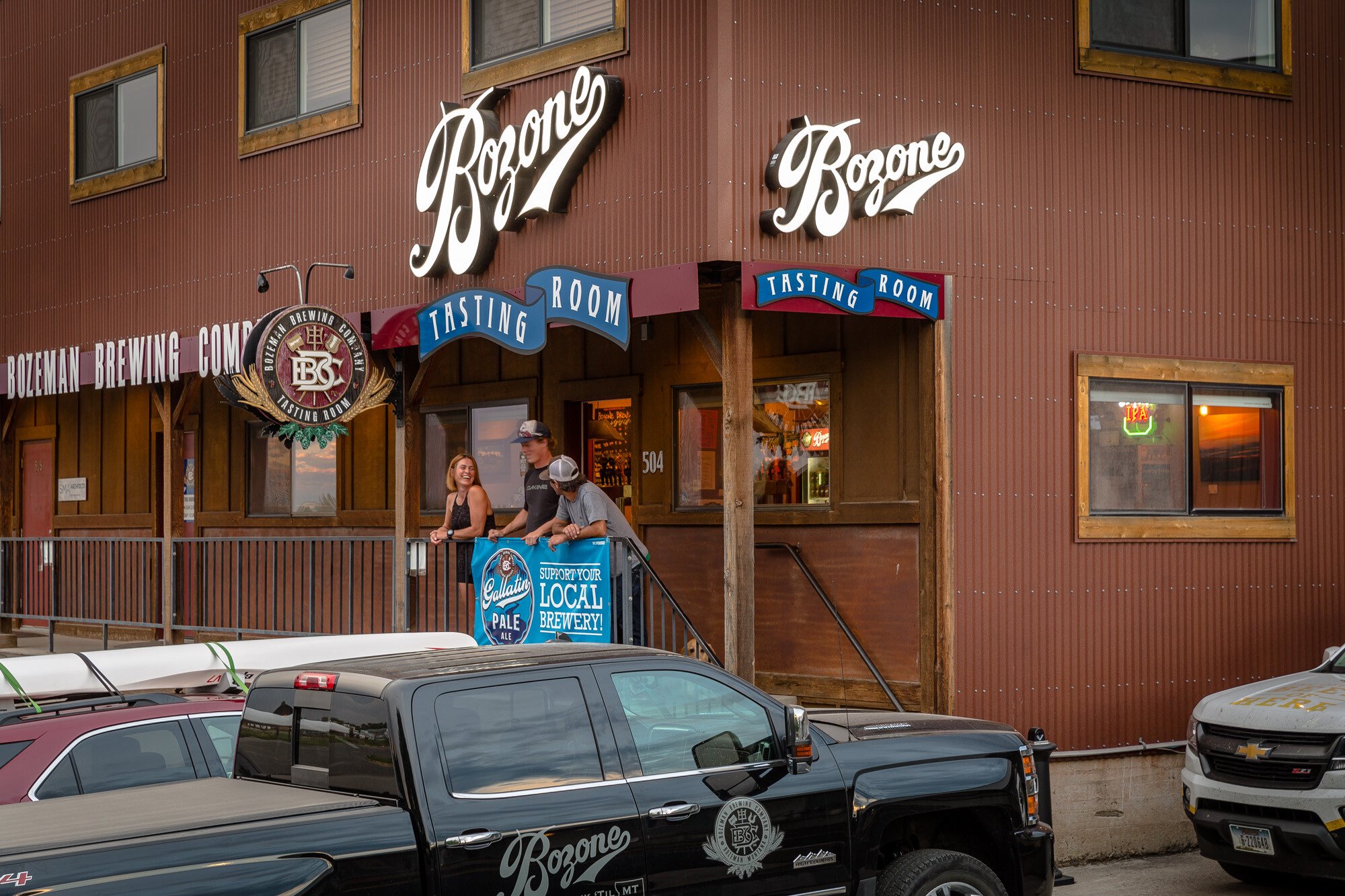 Three people standing and laughing outside Bozeman Brewing Company