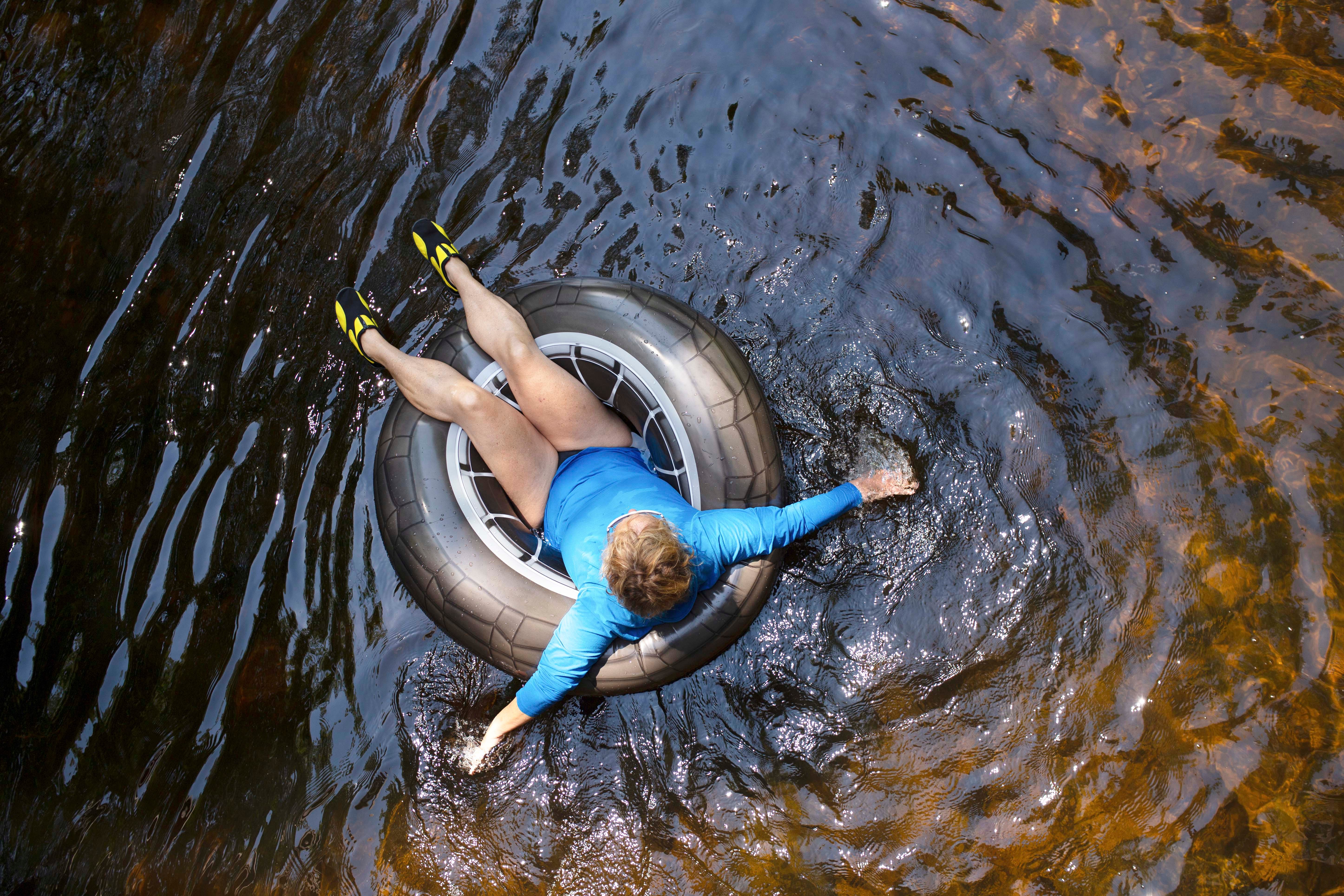 man floating on a river in a tire innertube