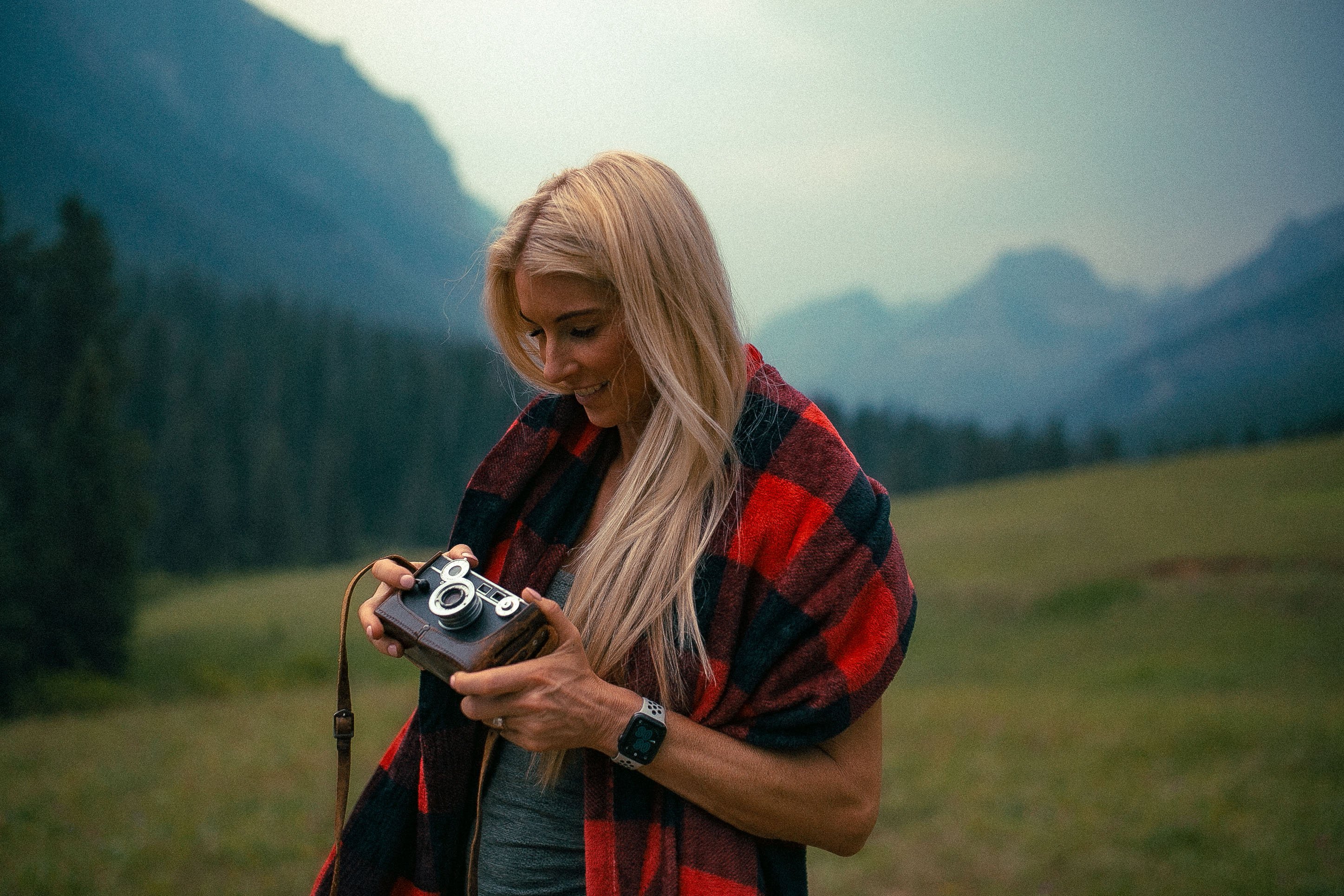Woman in the mountains with a camera