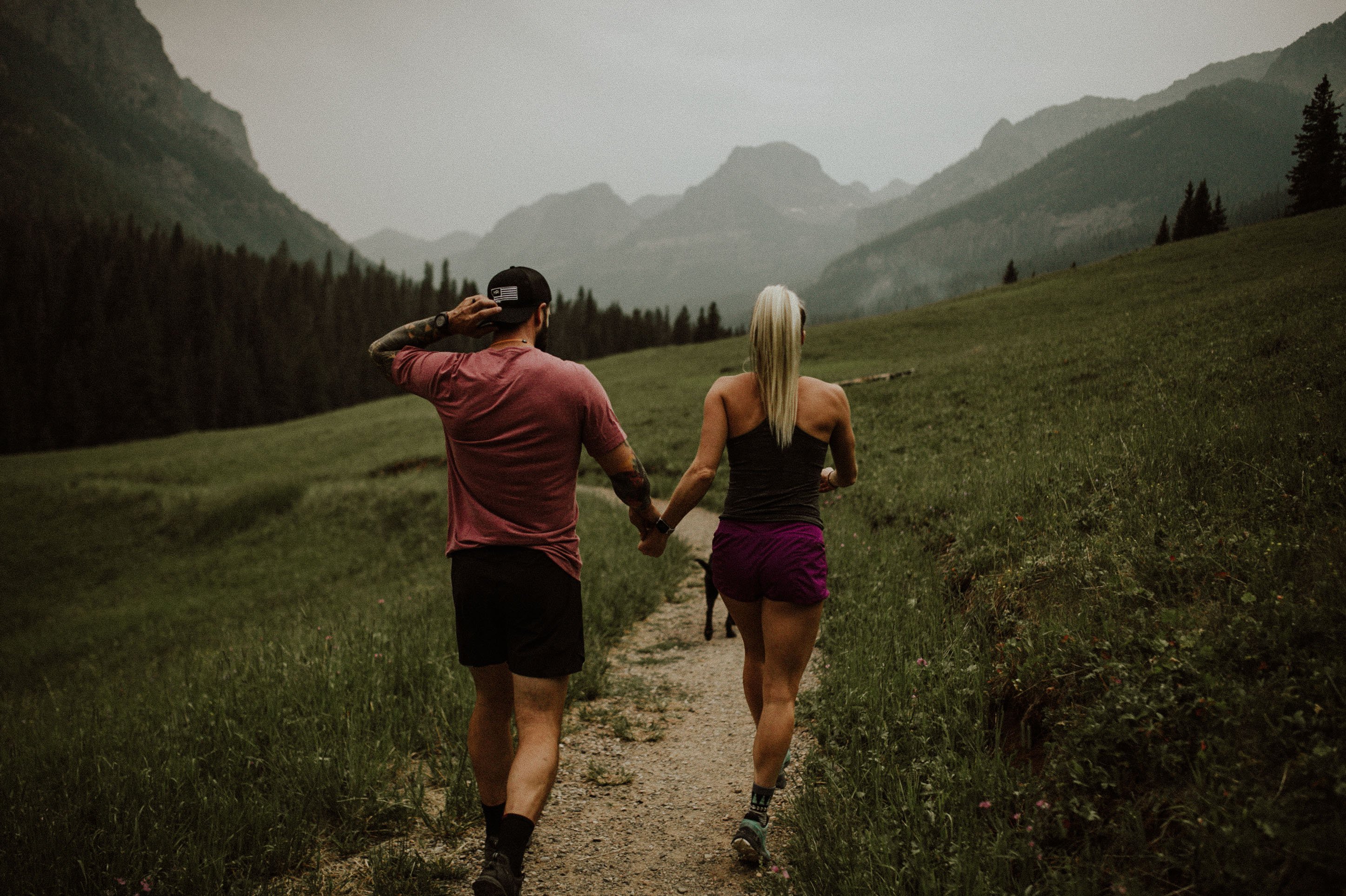 Photo of a couple hiking in the mountains, holding hands