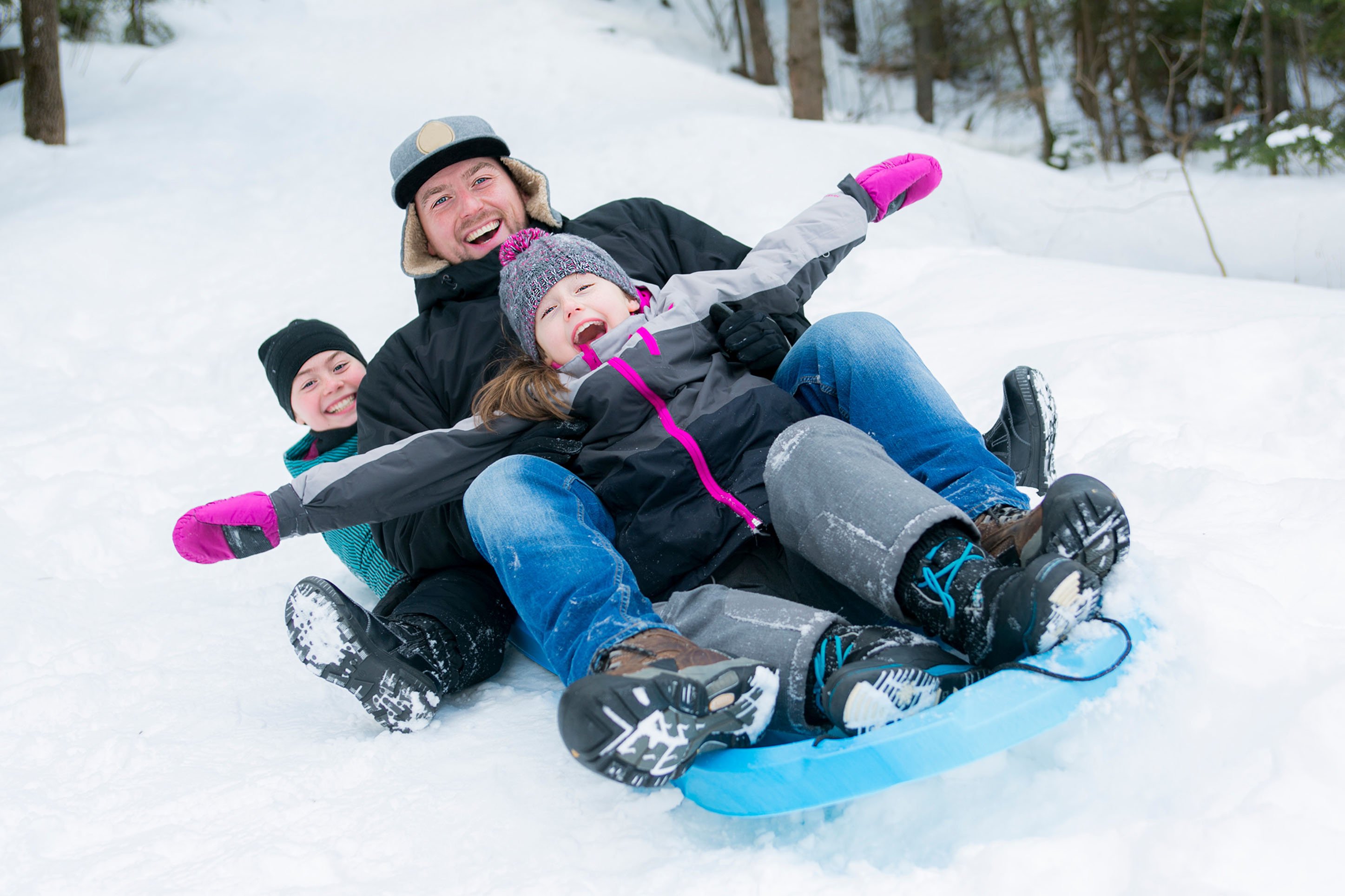 Dad sledding with two kids