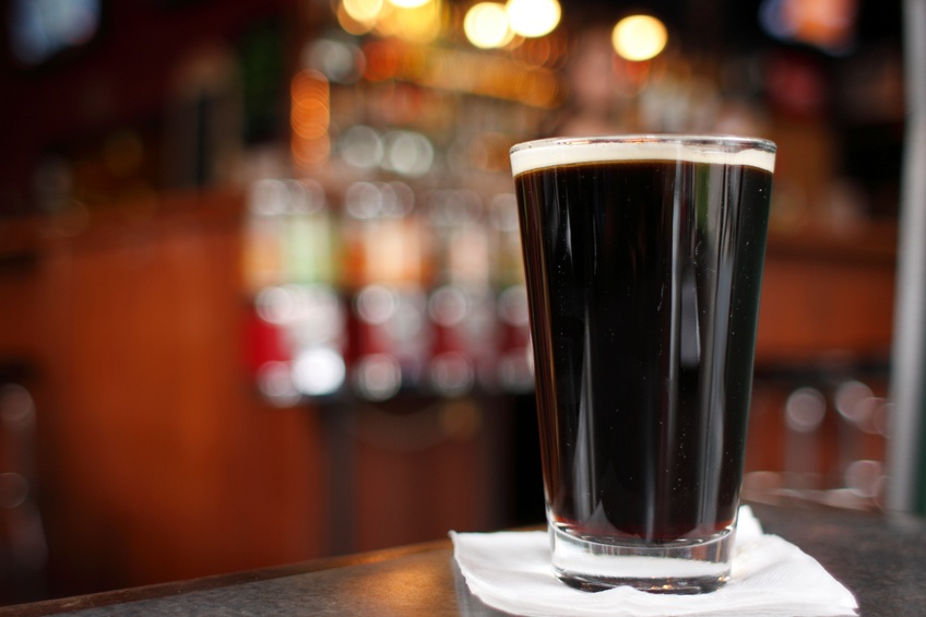 A dark beer on napkin in a brewery