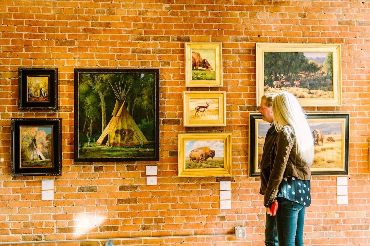 Man and woman looking at art in a coffee shop