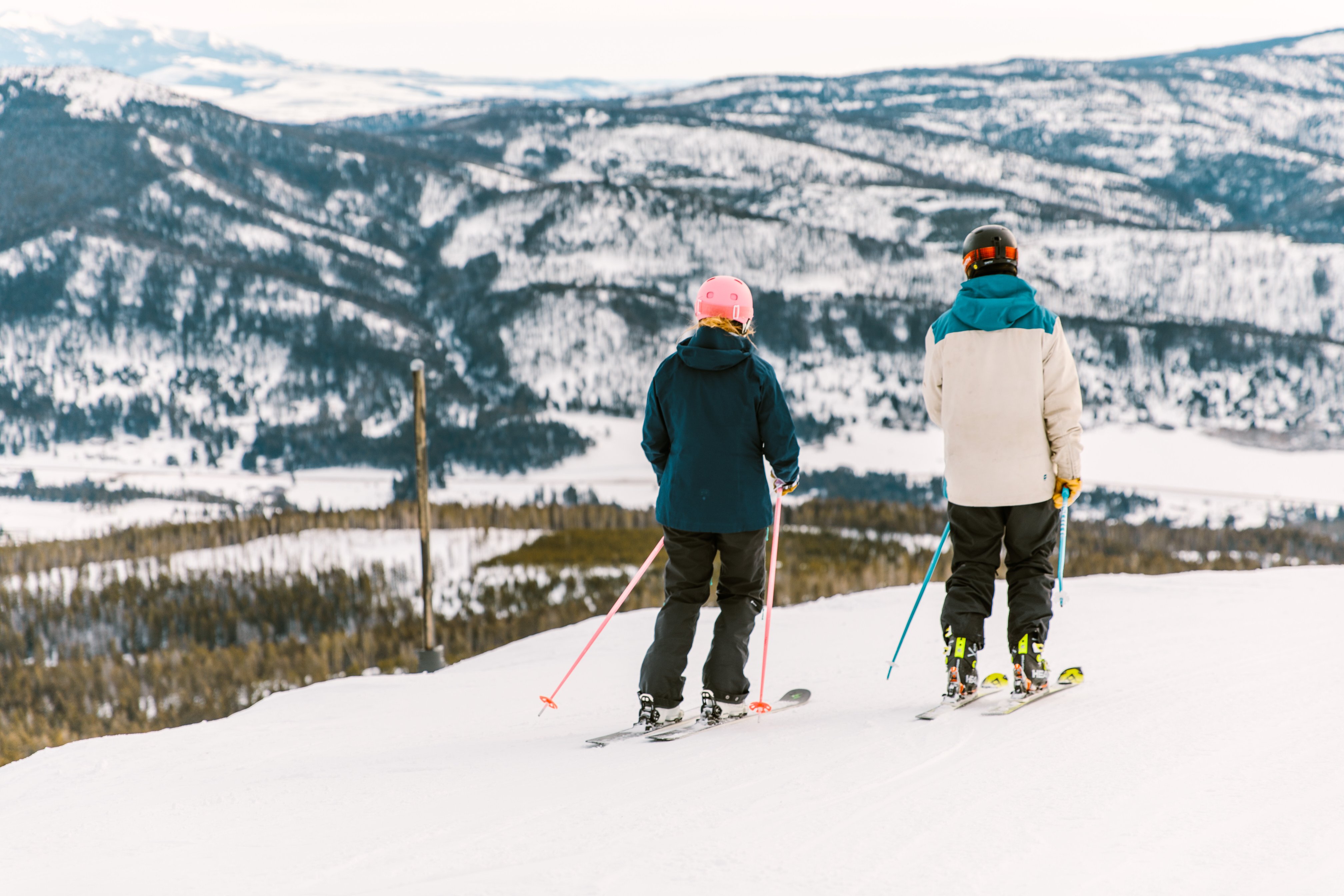 Two people skiing at Bridger Bowl Ski Area looking at the mountains