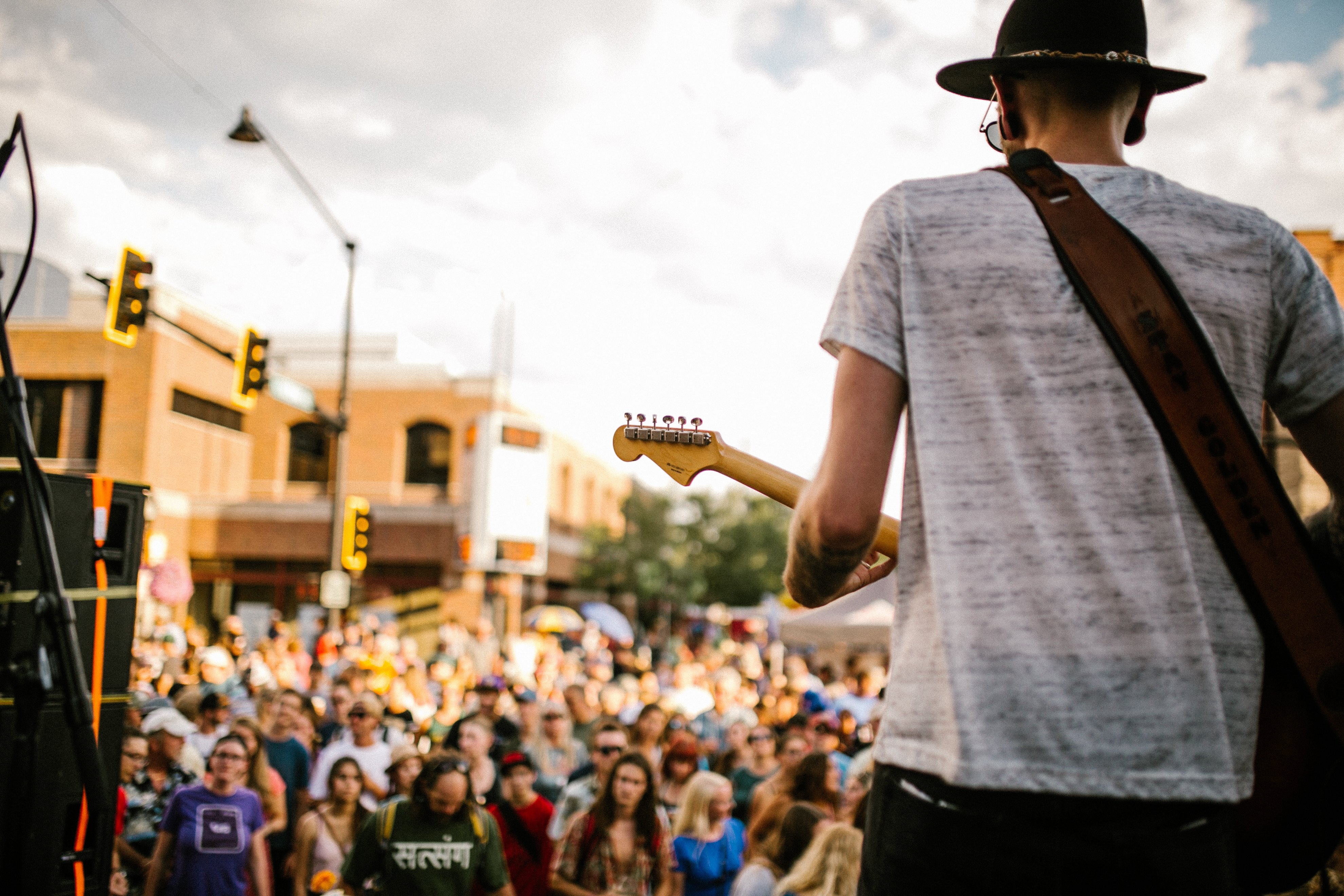 man playing guitar for audience at music on main